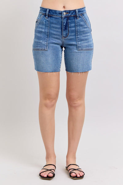 Mid-rise denim Bermuda shorts with raw hem and flap pockets, perfect for summer fashion from a women's boutique.