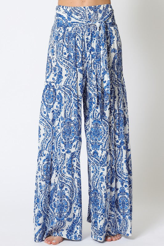 Blue & white paisley wide-leg tiered pants, perfect for summer resort wear. Shop exclusive women’s boutique clothing and new arrivals.