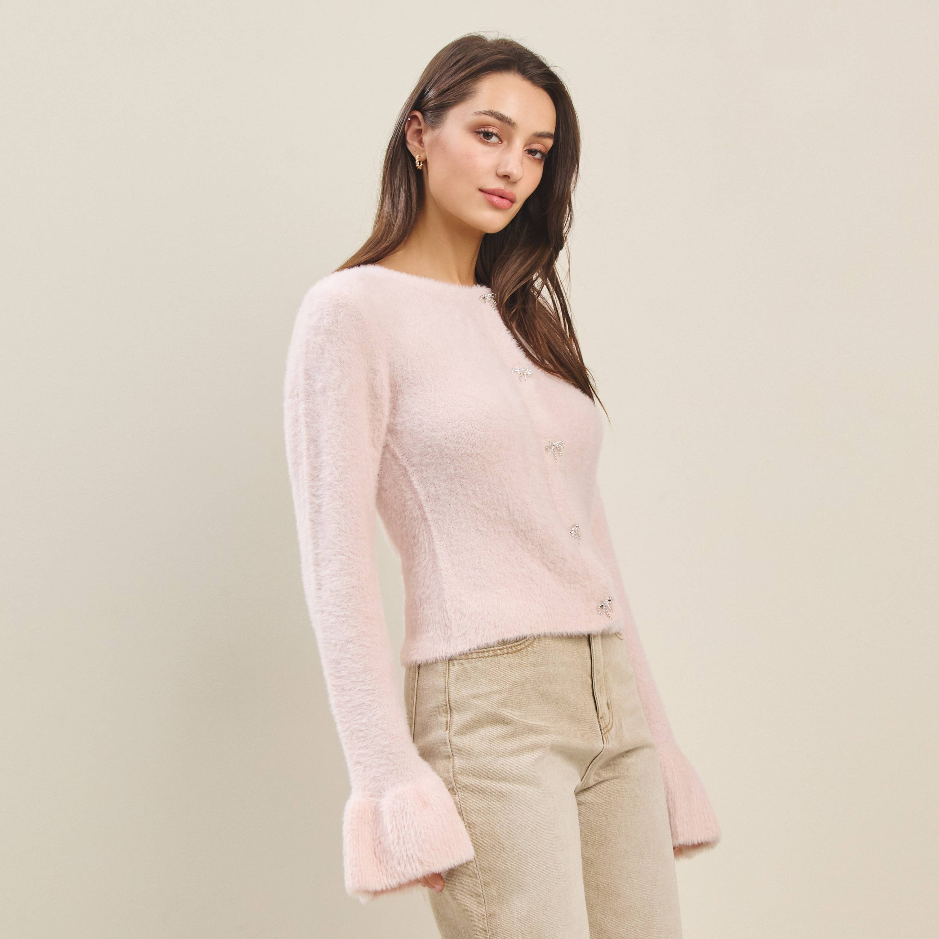 Rhinestone bow button fuzzy cardigan for women at boutique, perfect for summer collection. Stylish long sleeve knit top.