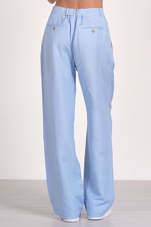 Light blue pleated pants with high-rise waist and side pockets, perfect for women's boutique clothing summer collection.
