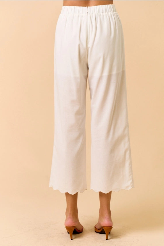 White scalloped edge pants with elastic waist and pockets, perfect for summer casual looks. Women's boutique clothing.
