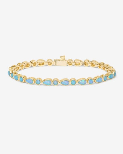 Elegant gold bracelet with blue stones, perfect for women's boutique clothing and summer collection jewelry.