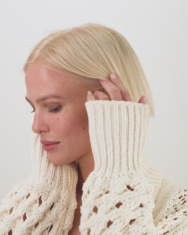 Blonde woman in a cozy knitted sweater, perfect for summer collection boutique and new arrivals in women's fashion.