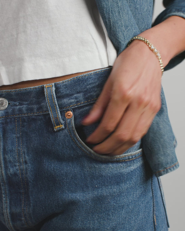 Woman wearing Baby Julian's Obsessed with Diamonds Bracelet with denim jeans and white top, showcasing exclusive women's fashion.